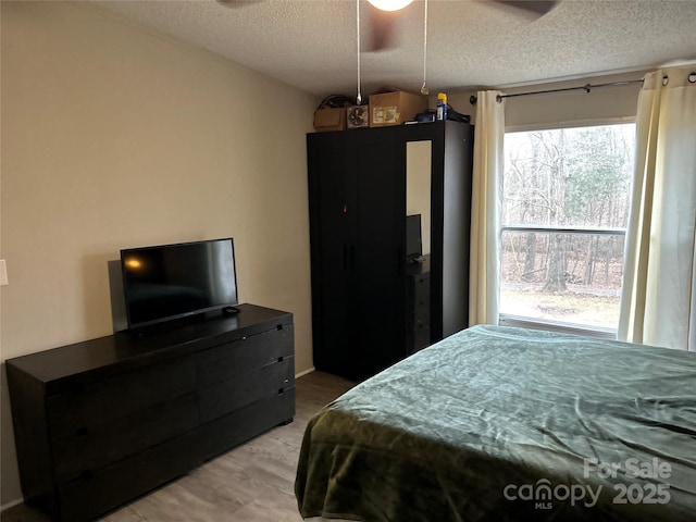 bedroom featuring wood-type flooring and a textured ceiling