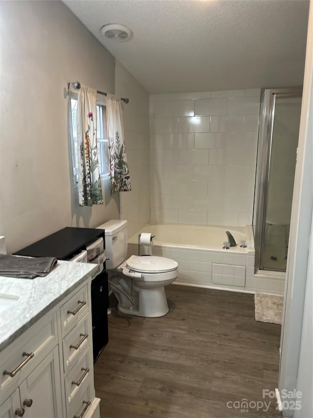 bathroom with hardwood / wood-style floors, vanity, a textured ceiling, vaulted ceiling, and toilet