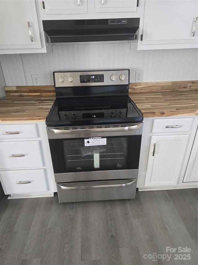 kitchen featuring white cabinets, dark hardwood / wood-style flooring, butcher block counters, and electric range