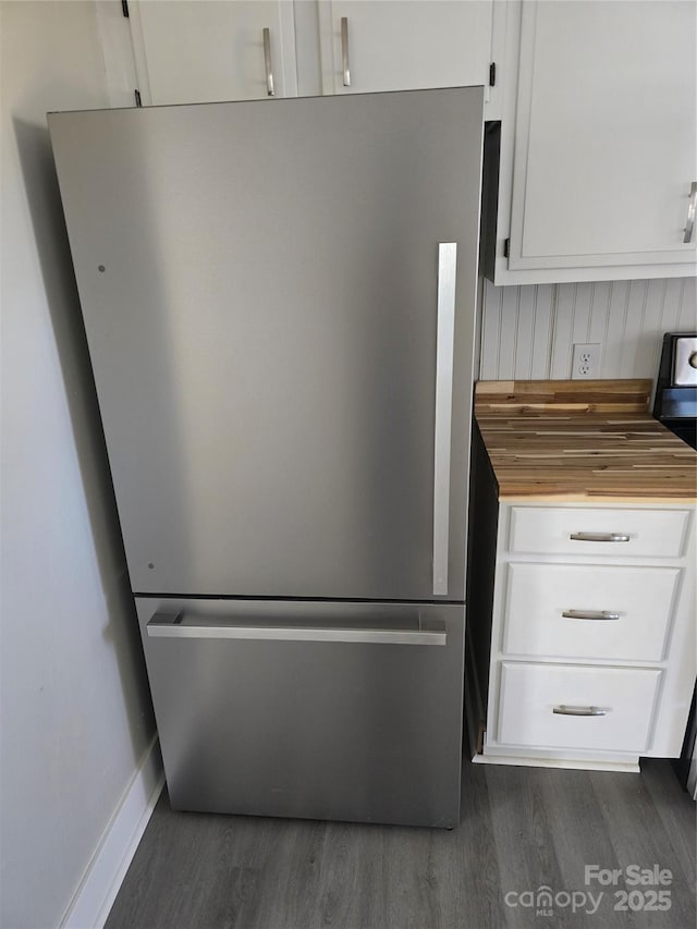 kitchen with stainless steel refrigerator, dark hardwood / wood-style flooring, butcher block counters, and white cabinets