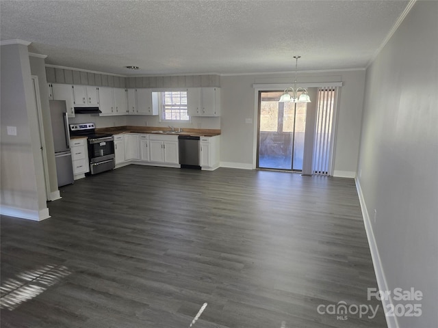 kitchen featuring white cabinetry, appliances with stainless steel finishes, pendant lighting, and a notable chandelier