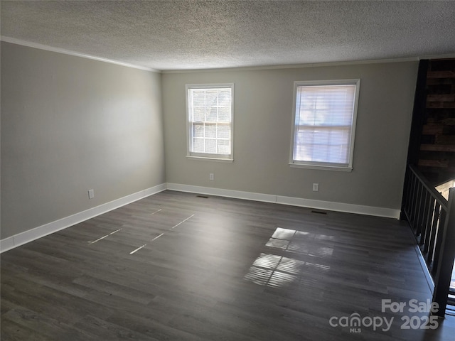 empty room featuring ornamental molding, dark hardwood / wood-style floors, and a textured ceiling