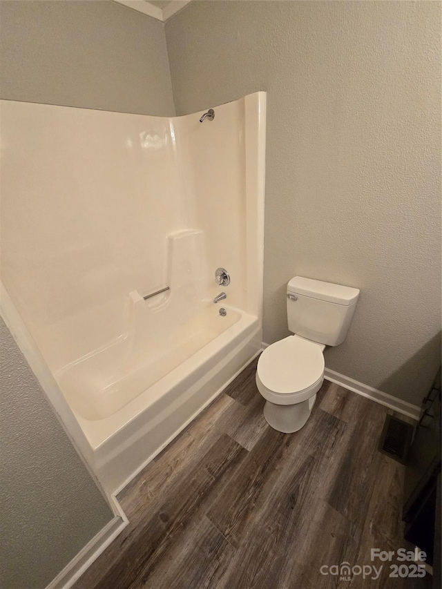 bathroom featuring shower / tub combination, toilet, and hardwood / wood-style floors