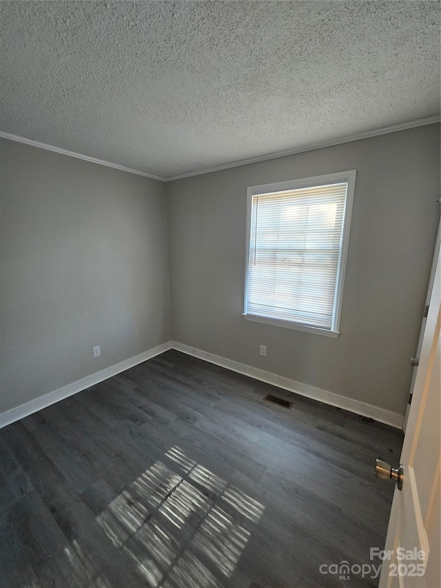 empty room with crown molding, dark hardwood / wood-style floors, and a textured ceiling