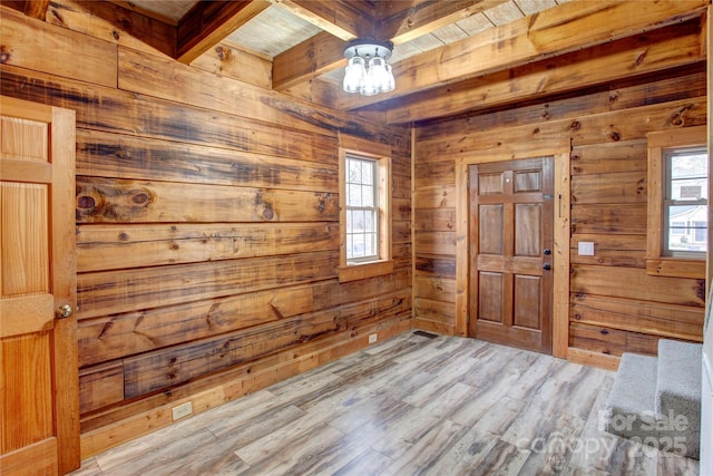 foyer with light hardwood / wood-style flooring, beam ceiling, wooden walls, and wooden ceiling