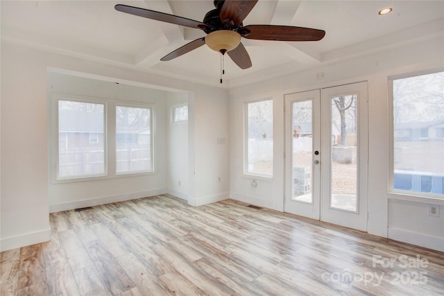 empty room with french doors, coffered ceiling, light hardwood / wood-style flooring, ceiling fan, and beam ceiling