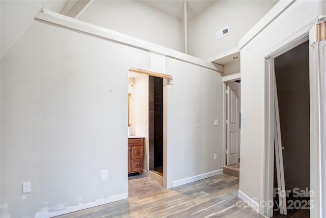 interior space featuring a towering ceiling and hardwood / wood-style floors