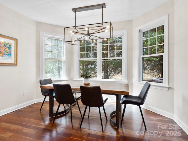 dining room with a wealth of natural light, dark hardwood / wood-style floors, and a chandelier