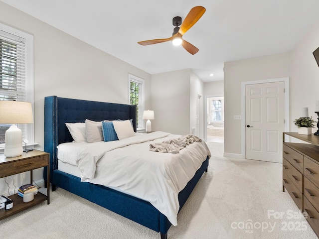 bedroom with light carpet, ceiling fan, and ensuite bath