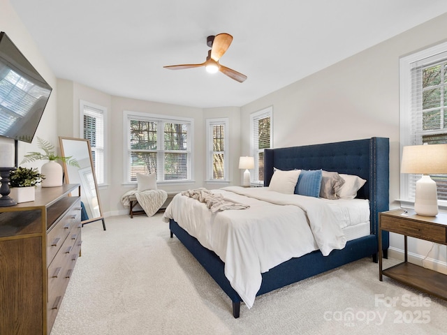 bedroom with multiple windows, light carpet, and ceiling fan