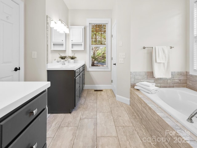 bathroom featuring vanity and tiled tub