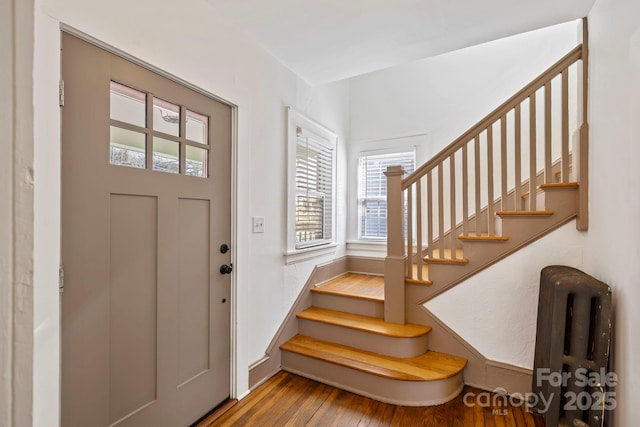 foyer entrance featuring radiator and hardwood / wood-style floors