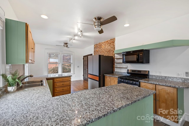 kitchen featuring ceiling fan, appliances with stainless steel finishes, kitchen peninsula, and sink