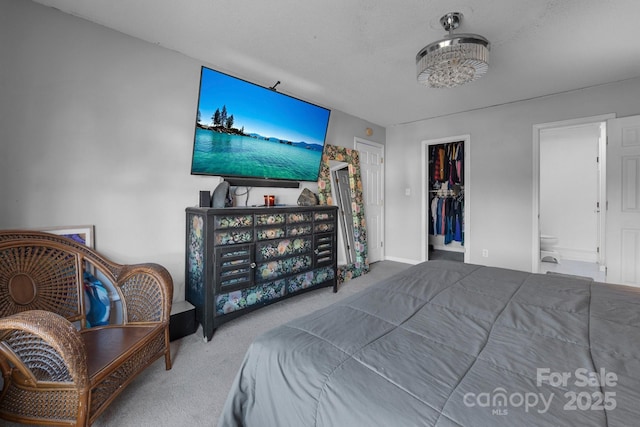 bedroom with ensuite bath, carpet flooring, a walk in closet, a textured ceiling, and a closet