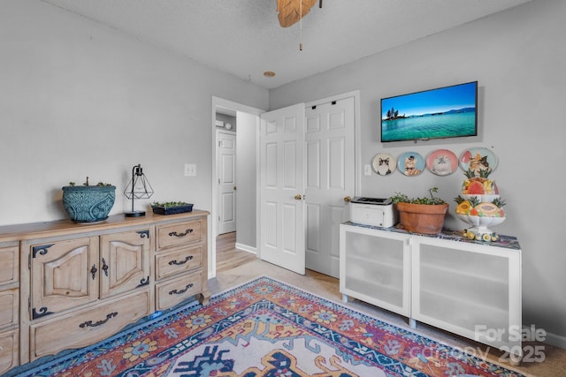 bedroom with ceiling fan and a textured ceiling