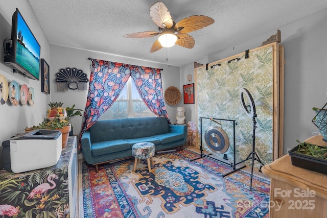 living room with ceiling fan and a textured ceiling