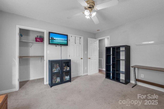 unfurnished living room with light carpet and ceiling fan