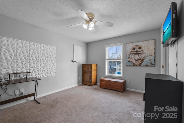 misc room featuring ceiling fan, light carpet, and a textured ceiling