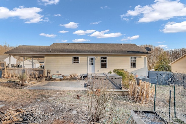 rear view of house with central AC, a hot tub, and a patio