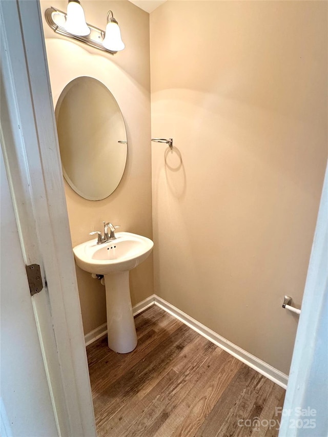 bathroom featuring a sink, baseboards, and wood finished floors