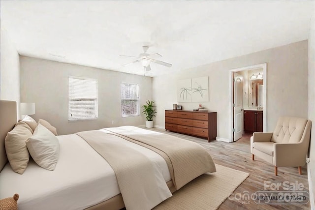 bedroom with light wood finished floors, ceiling fan, baseboards, and ensuite bathroom