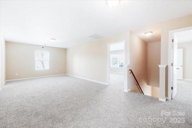 empty room with visible vents, baseboards, and carpet flooring