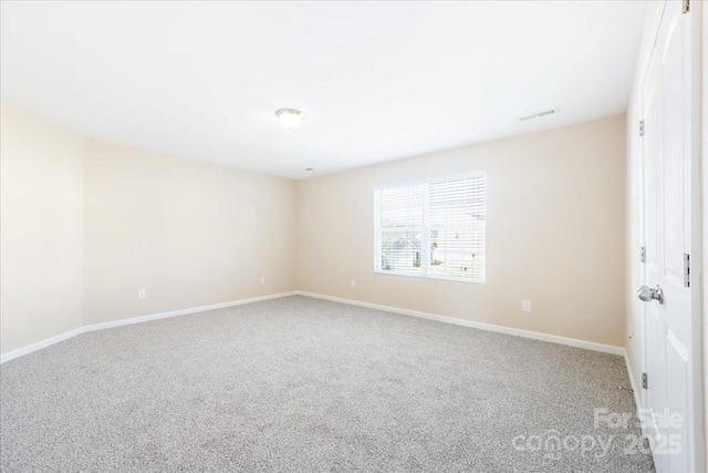 spare room featuring carpet, visible vents, and baseboards