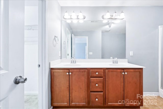 bathroom featuring a sink, baseboards, and double vanity