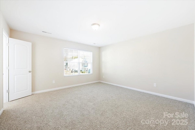 carpeted spare room featuring visible vents and baseboards