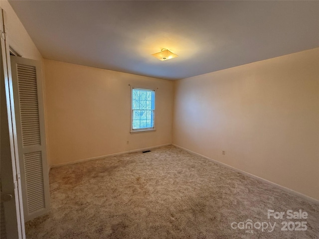 unfurnished bedroom featuring light carpet and a closet