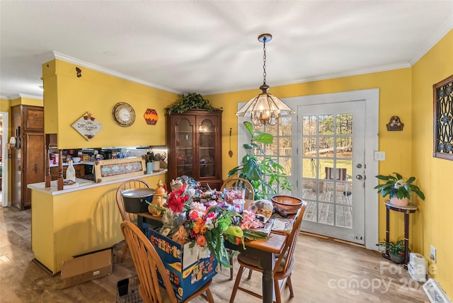 dining room with ornamental molding and a chandelier