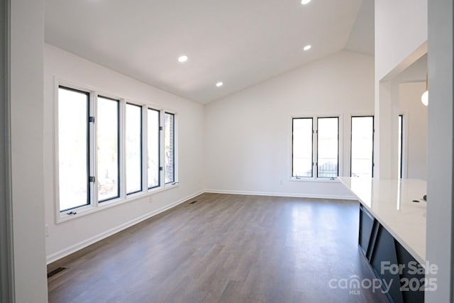 unfurnished room featuring vaulted ceiling and dark hardwood / wood-style floors