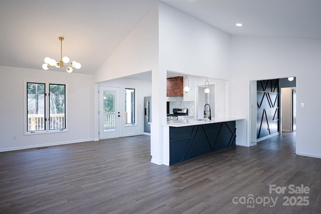 kitchen with pendant lighting, dark hardwood / wood-style floors, high vaulted ceiling, and kitchen peninsula