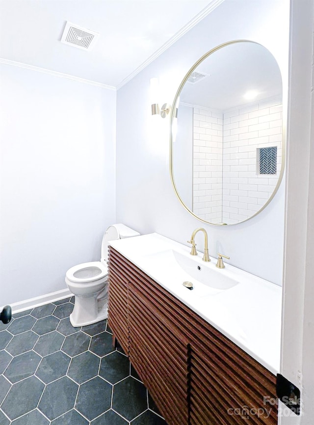 bathroom with vanity, ornamental molding, and toilet