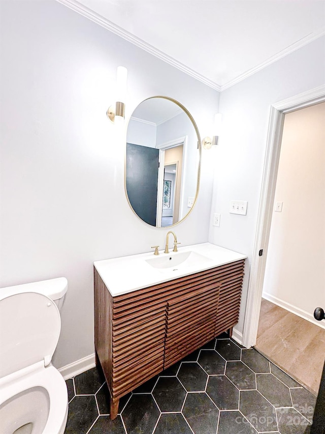 bathroom with crown molding, vanity, and toilet