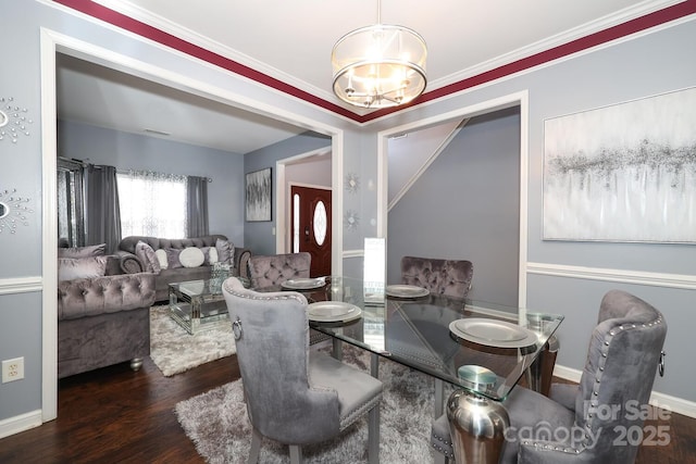 dining area featuring a notable chandelier, dark wood-type flooring, and ornamental molding