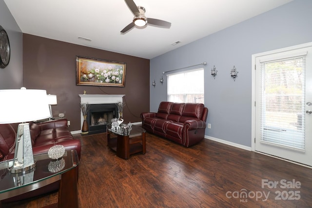 living room with dark hardwood / wood-style flooring, plenty of natural light, and ceiling fan