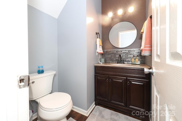 bathroom featuring vanity, wood-type flooring, toilet, and decorative backsplash