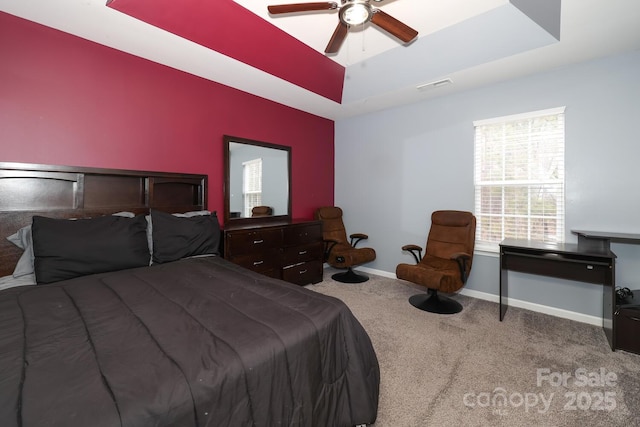 bedroom featuring carpet floors, a raised ceiling, and ceiling fan