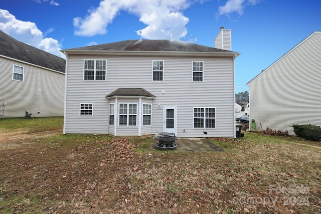 back of house with a yard, a fire pit, and a patio area