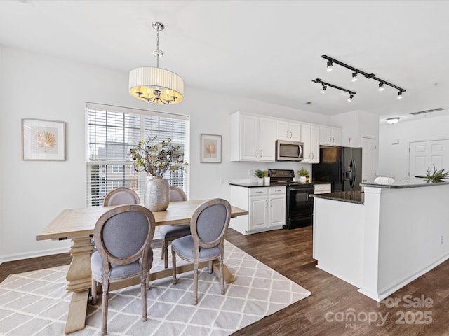 kitchen with white cabinetry, dark hardwood / wood-style flooring, hanging light fixtures, a notable chandelier, and black appliances