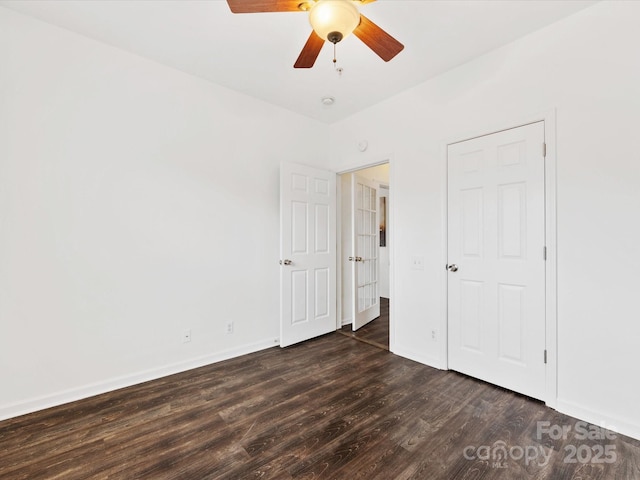 unfurnished bedroom with ceiling fan and dark hardwood / wood-style flooring