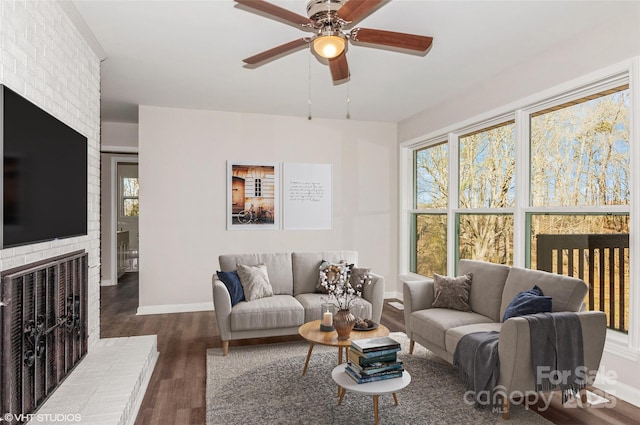 living room with ceiling fan, a fireplace, dark hardwood / wood-style flooring, and a wealth of natural light