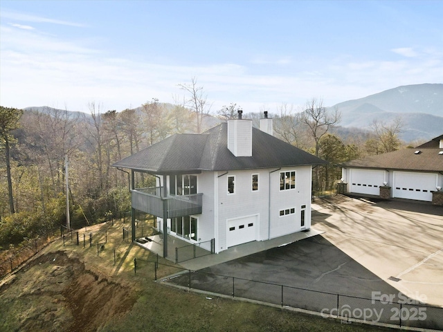 view of property exterior with a balcony and a mountain view