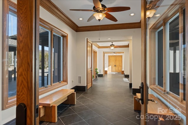 corridor featuring dark tile patterned floors and ornamental molding