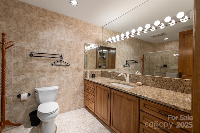 bathroom featuring tile walls, vanity, tile patterned floors, toilet, and walk in shower