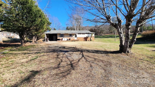 ranch-style home featuring a carport and a front lawn