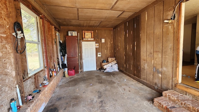 misc room with wooden ceiling, concrete floors, and wood walls