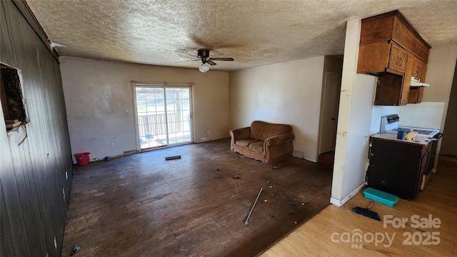 unfurnished room with dark wood-type flooring, ceiling fan, and a textured ceiling