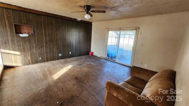 spare room featuring ceiling fan and wood walls